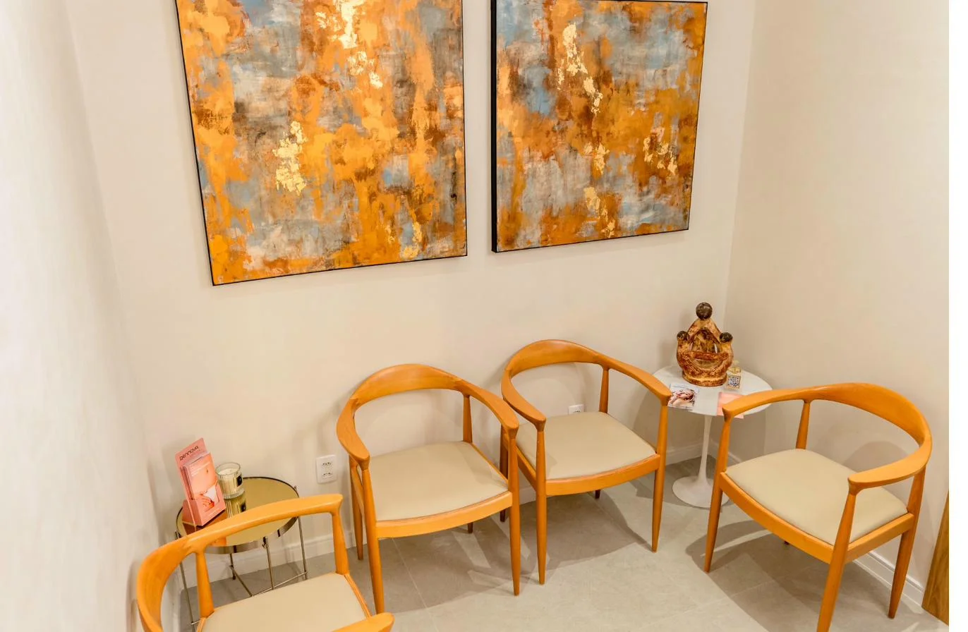 Sala de espera da clínica, com poltronas e quadros